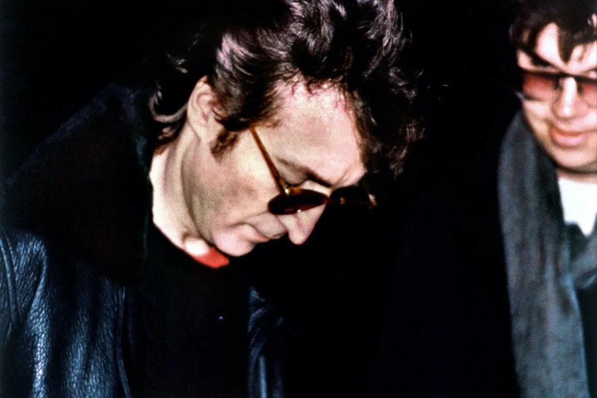 John Lennon mentre firma un autografo a Mark Chapman la sera dell'8 dicembre 1980. Quella stessa sera Chapman esplose cinque colpi di pistola contro l'ex Beatle